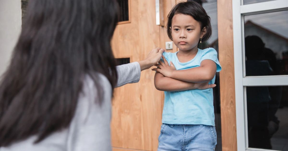 Mother using gentle parenting approach with her child outside a Filipino home, showing connection instead of punishment.
