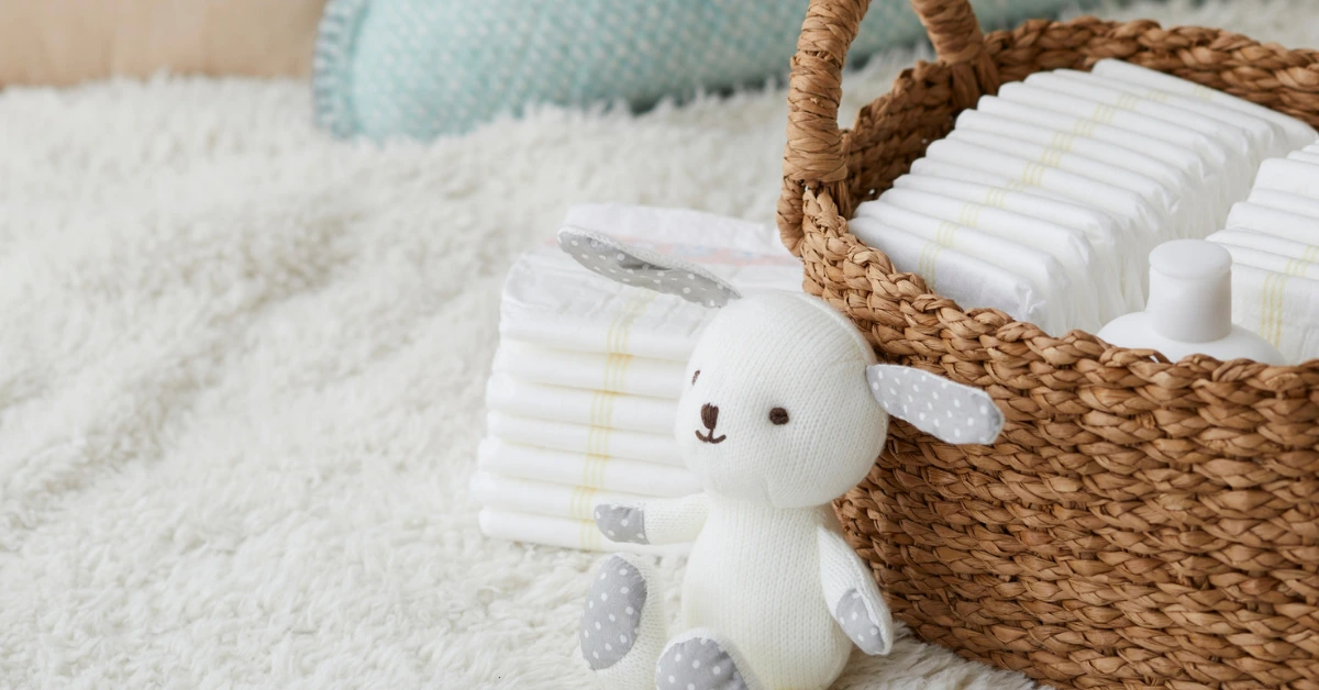 Newborn poop colors concept with stack of diapers in a woven basket and soft bunny plush on a white rug.