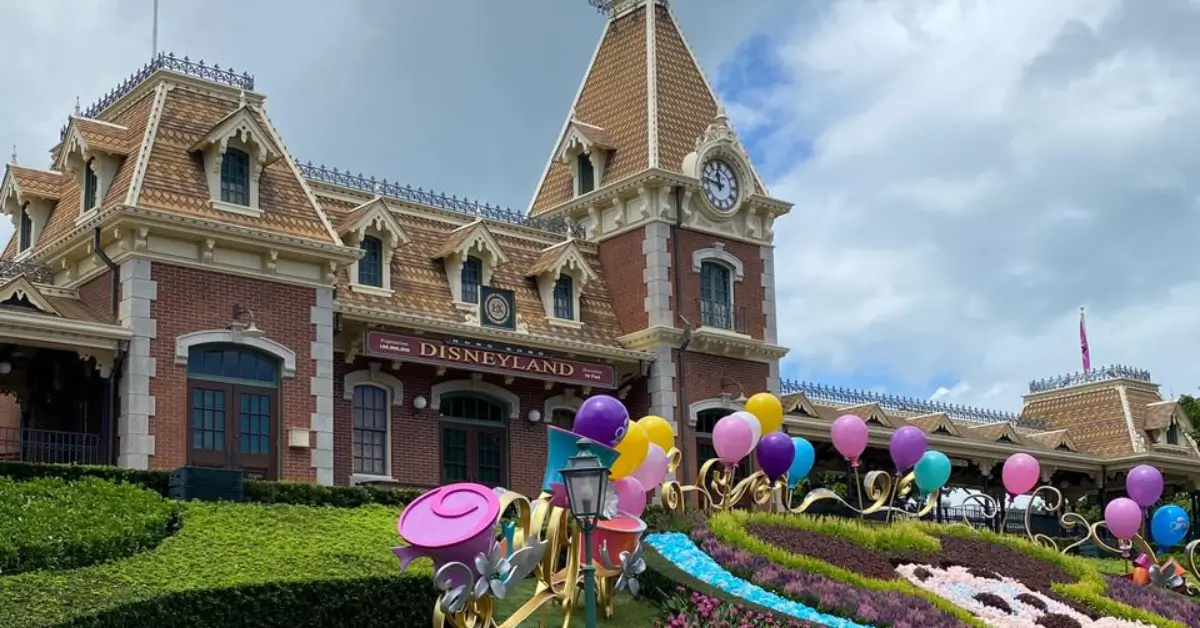 Hong Kong Disneyland entrance with balloons and clock tower during our family trip with kids.