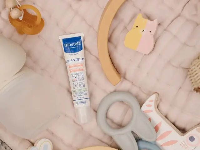 Tube of Mustela Cicastela cream placed on baby playmat with toys, used for soothing HFMD rashes in kids.